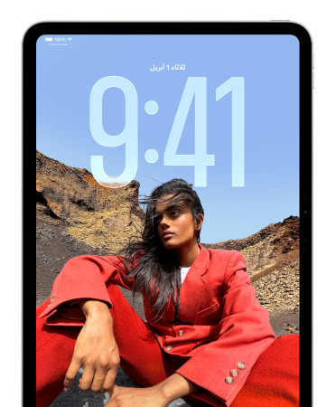 iPad يعرض شاشة القفل حيث تظهر أرقام كبيرة للوقت خلف صورة شخص جالس