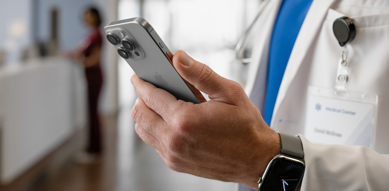 Hendene til en lege som holder en iPhone.