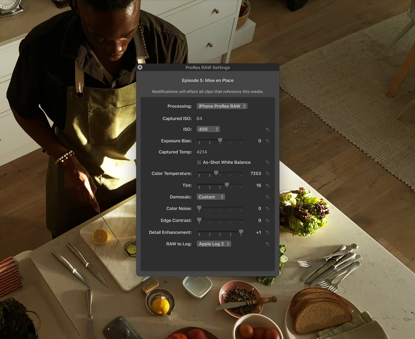iPhone 17 Pro front screen showing pro workflows for video, a man stands at a kitchen counter and chops vegetables.