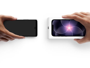 Two hands side-by-side, hand holding Android without box, trade-in, with hand holding new iPhone 17e box