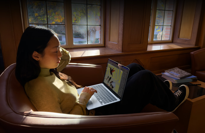 의자에 앉아 MacBook Air를 사용 중인 사람의 모습