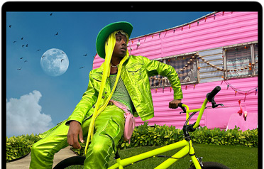 Liquid Retina 디스플레이의 색상 범위와 해상도를 보여주기 위한 예시로 컬러풀한 옷을 입은 사람의 사진을 띄워둔 MacBook Air 화면