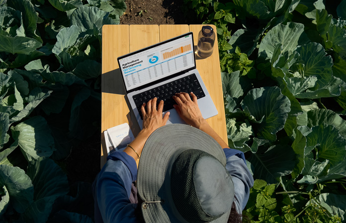Une personne utilise en extérieur un MacBook Pro avec écran nano-texturé, illustrant la réduction des reflets