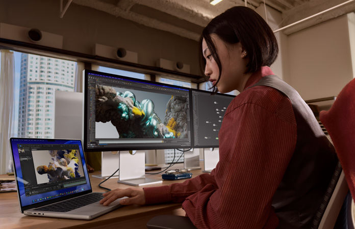 MacBook Pro 接上兩部 Studio Display，螢幕展示正在準備領袖高峰會、在 Trello app 中追蹤工作事項、準備簡報，並透過電郵檢視設計檔案