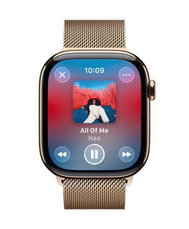 Un Apple Watch de titanio en oro con correa Milanese Loop muestra la app Apple Music reproduciendo una canción con los controles en Liquid Glass